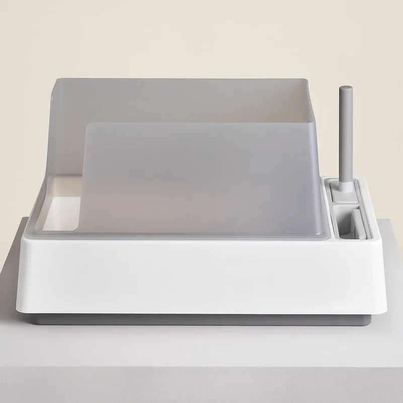 The Cove litter box, a white open tray with high sides and a scoop stored at the back